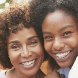 Woman and her teen daughter smiling